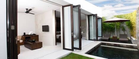 A modern house with an open-plan living area, a pool, and outdoor seating.