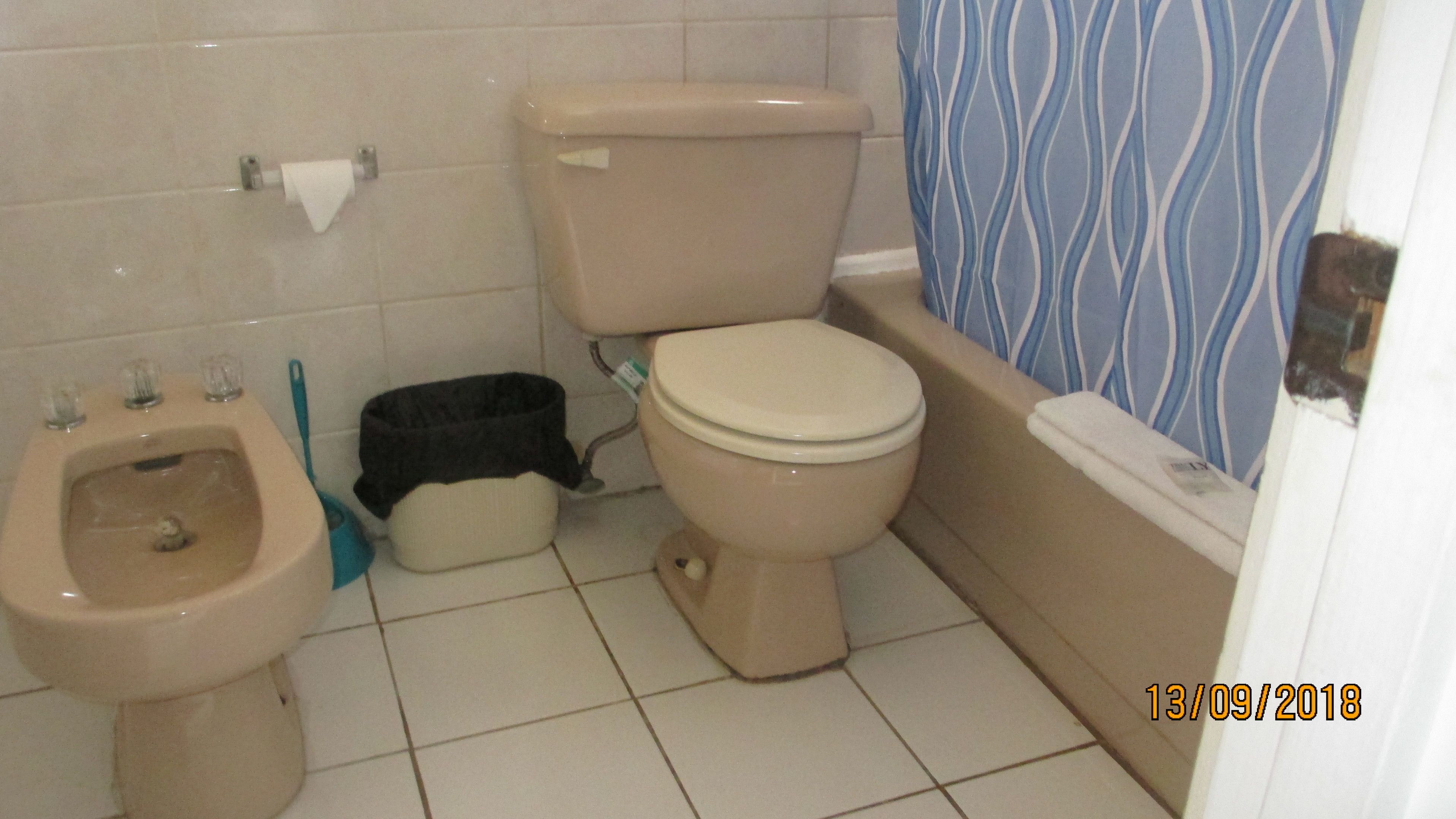 Une petite salle de bain comprenant des toilettes, un bidet et une poubelle.
