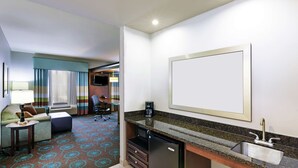 A hotel room with a kitchenette, a sofa, a small table, a TV, and a window with curtains. - Hampton Inn & Suites Shreveport/Bossier City Airline Drive (Bossier City)