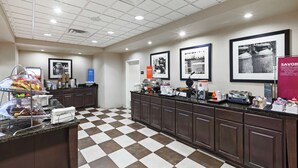 A clean, well-lit kitchen area with checkered flooring, a buffet setup, and framed pictures on the wall. - Hampton Inn & Suites Shreveport/Bossier City Airline Drive (Bossier City)