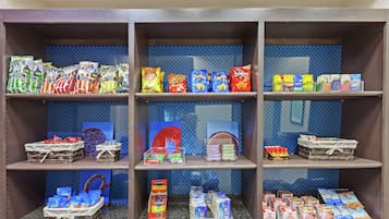 A snack display with various brands like Lay's, Cheetos, Doritos, and Pringles.
