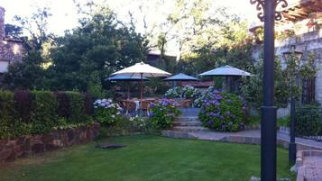A well-maintained garden with a lawn, outdoor seating, and stone walls.