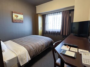 A hotel room with a bed, a desk with a TV, a telephone, and a window with curtains. - Hotel Route-Inn Natori (Natori)