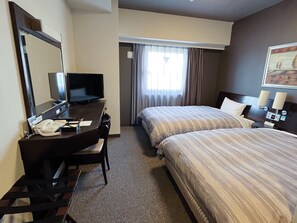 A hotel room with a desk, television, two beds, and a large mirror. - Hotel Route-Inn Natori (Natori)