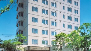 A multi-story hotel with a modern facade, featuring a prominent sign at the top and a ground-level entrance with a visible reception area. - Hotel Route-Inn Dai-Ni Nagano (Nagano)