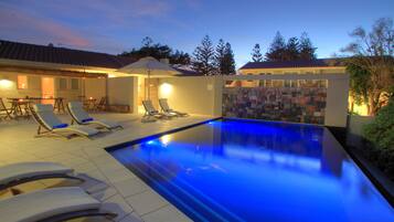 Alberca al aire libre y camastros