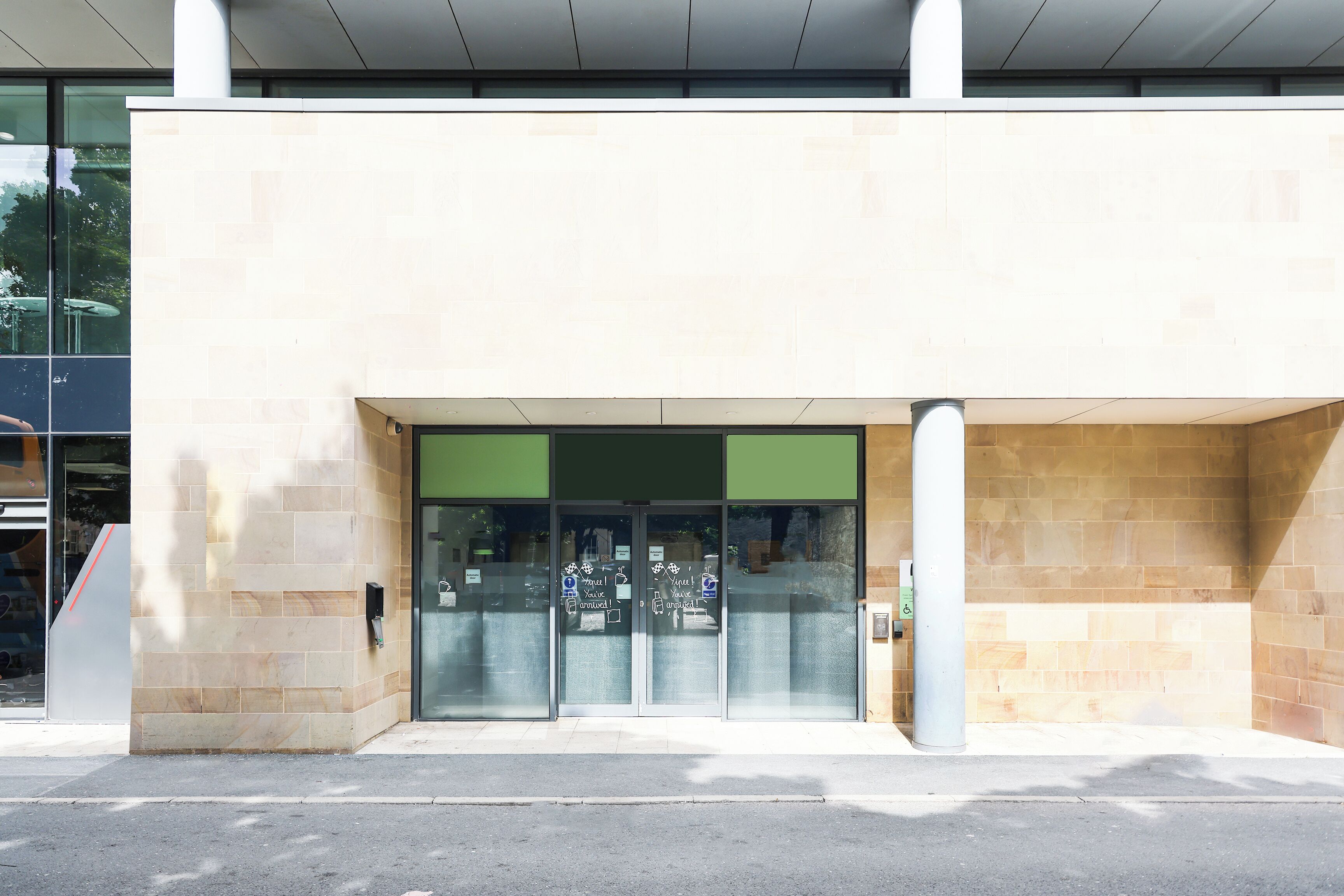 A building entrance with a glass door and a green awning.