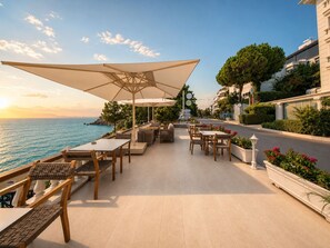 An outdoor patio with tables and chairs, overlooking a body of water. - Massimo Hotel - Adults Only 'Ex La Boutique Hotels (Antalya)