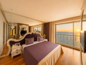 A bedroom with a large bed, a nightstand, a mirror, and a view of the sea. - Massimo Hotel - Adults Only 'Ex La Boutique Hotels (Antalya)