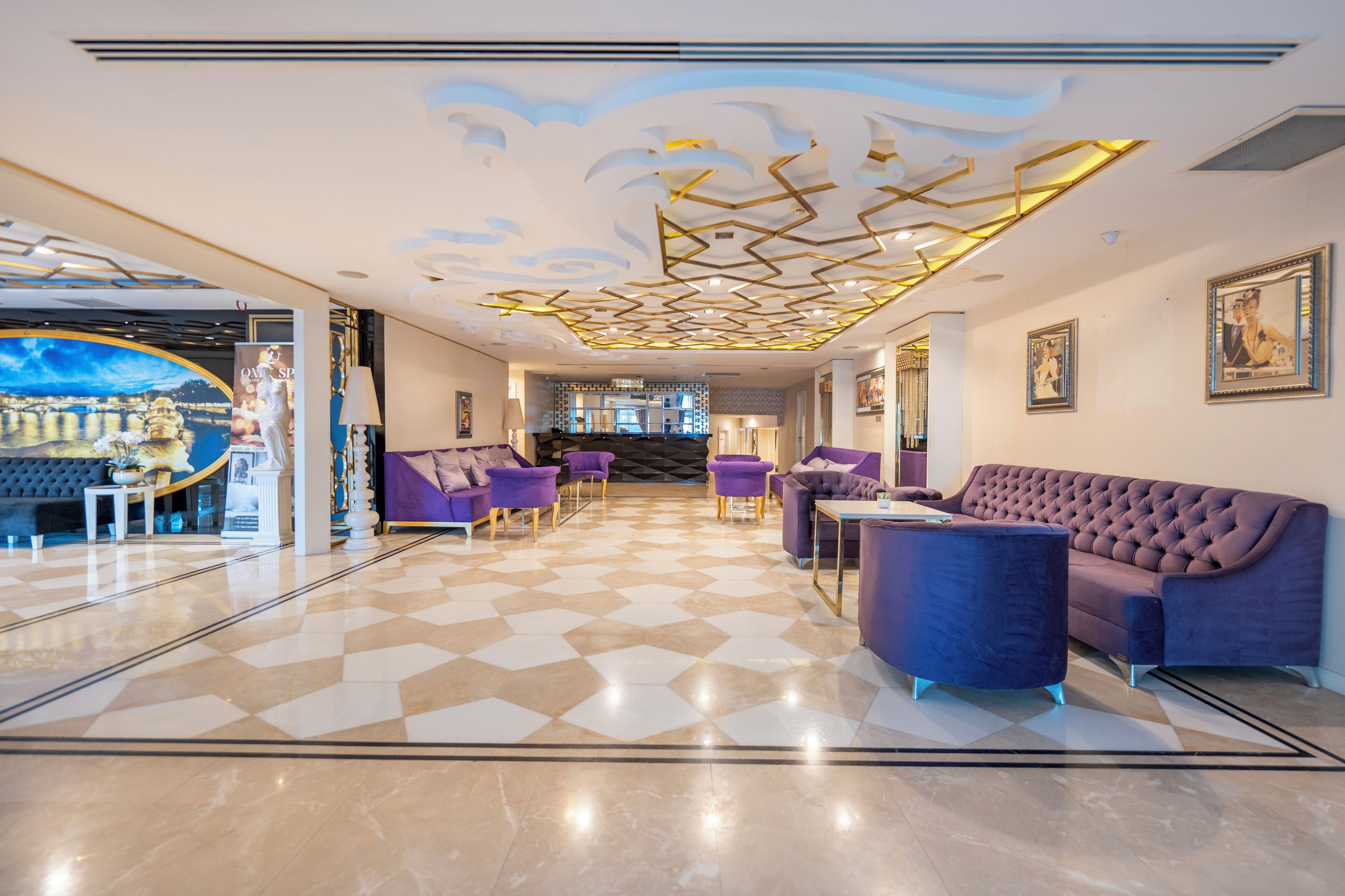 A hotel lobby with a checkered floor, a purple sofa, and a chandelier.