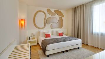 Ein modernes Schlafzimmer mit einem großen Bett, einem Nachttisch und einem Beistelltisch, sowie abstrakter Wandkunst.