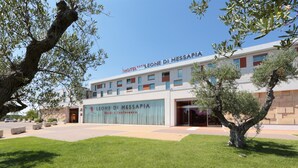 A hotel named "LEONE DI MESSAPIA" with a modern facade, large windows, and a well-maintained lawn. - Best Western Plus Leone di Messapia Hotel & Conference (Lecce)