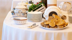 A buffet table with various food items and serving dishes, a decorative vase with greenery, and a mirror in the background. - Best Western Plus Leone di Messapia Hotel & Conference (Lecce)