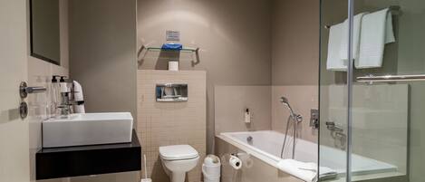 A modern bathroom with a glass-enclosed shower, a white sink, and a toilet.