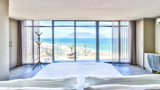 Ein Schlafzimmer mit einem großen Bett, Meerblick und einem Balkon.