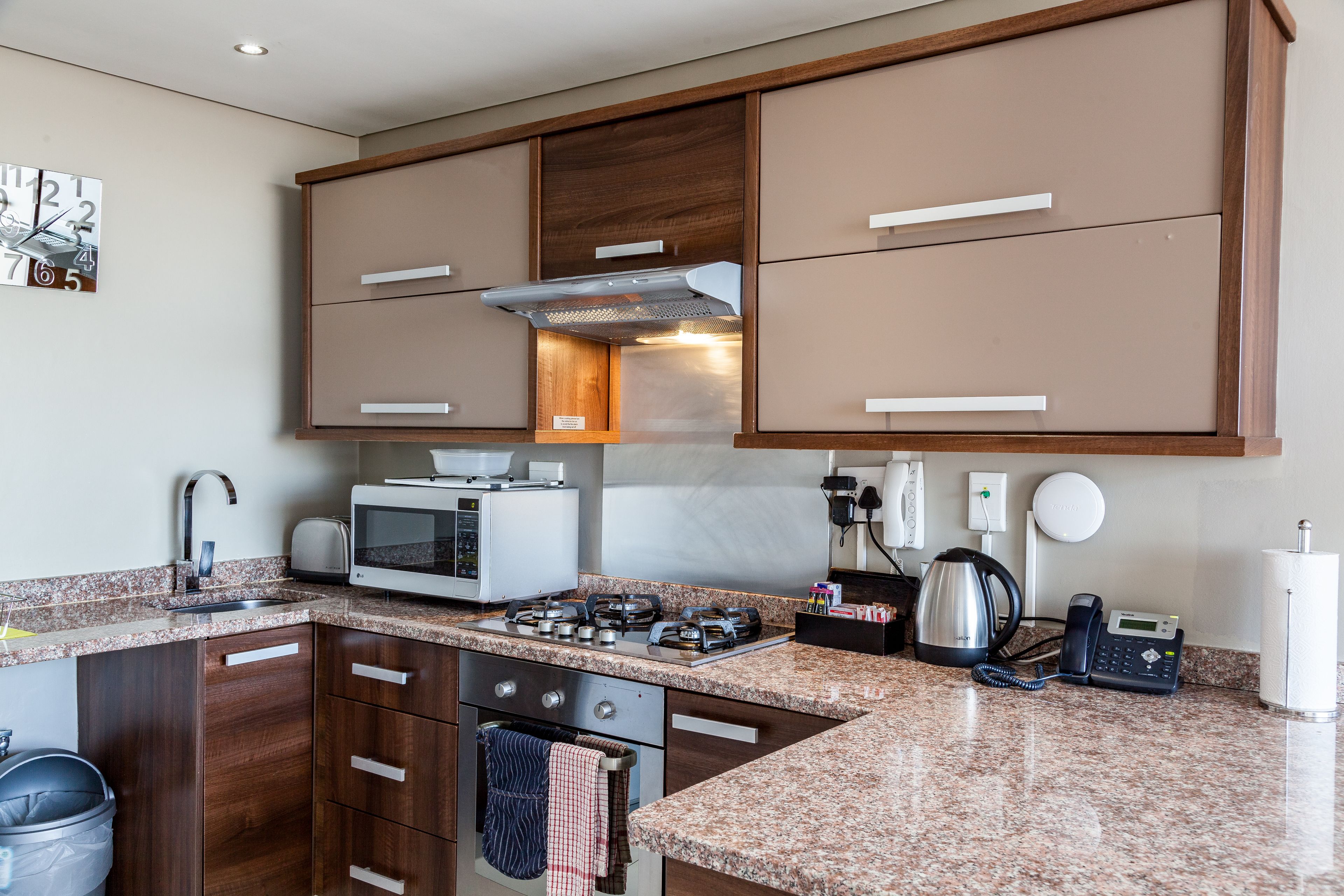 A modern kitchen with granite countertops, stainless steel appliances, and wooden cabinets.