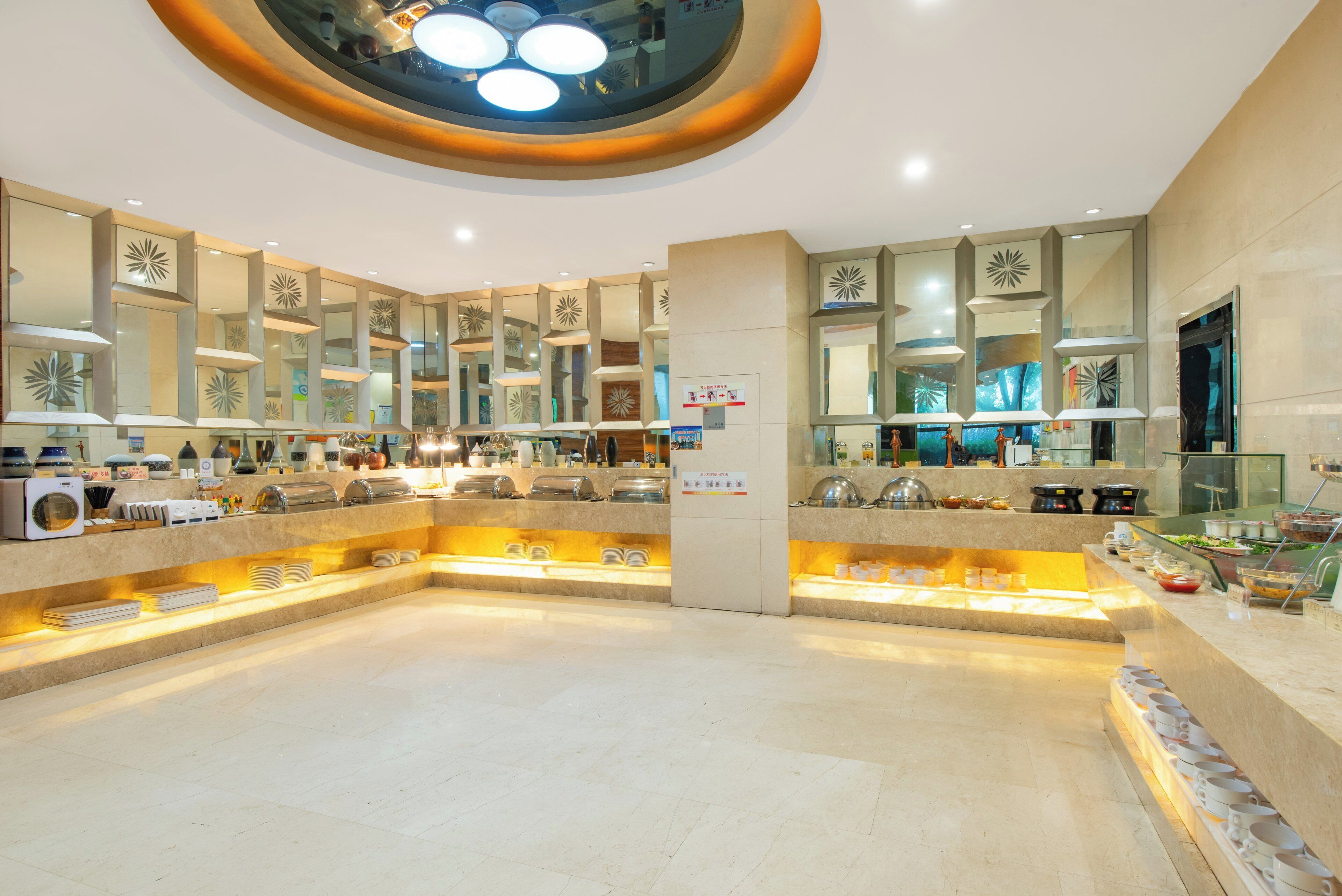 Un vestíbulo de hotel con una zona de estar central, varios mostradores de servicio y espejos decorativos.