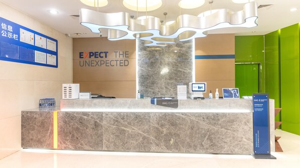 A reception desk with a marble top, a digital kiosk, and a sign indicating 'Diamond Elite' and 'Platinum Elite' rooms.