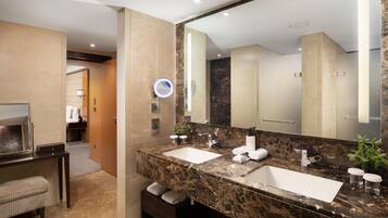 Un baño moderno con dos lavamanos, un espejo grande y un tocador con encimera de mármol.