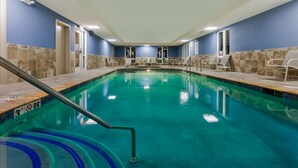 A swimming pool with a 3 ft depth limit, surrounded by chairs and a tiled wall. - Holiday Inn Express Salinas by IHG (Salina)