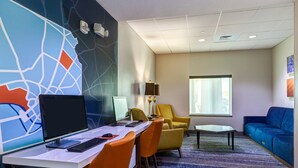 A hotel room with a desk, computer, chairs, a sofa, a lamp, and a large window. - Holiday Inn Express Salinas by IHG (Salina)