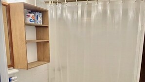 A bathroom with a toilet, sink, and shower curtain. - Hotel Rio Bueno (Rio Bueno)