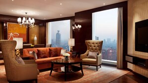 Una sala de estar moderna con un sofá, sillones, una mesa de centro y un televisor.