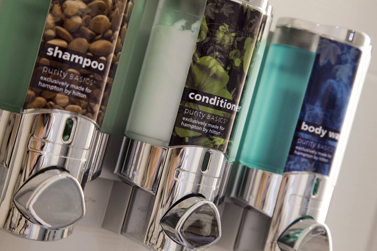 A row of toiletries with labels indicating they are made by Hampton by Hilton.