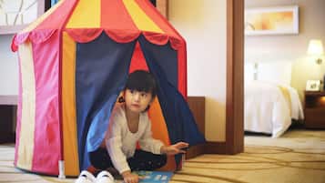 A child playing inside a colorful tent structure.