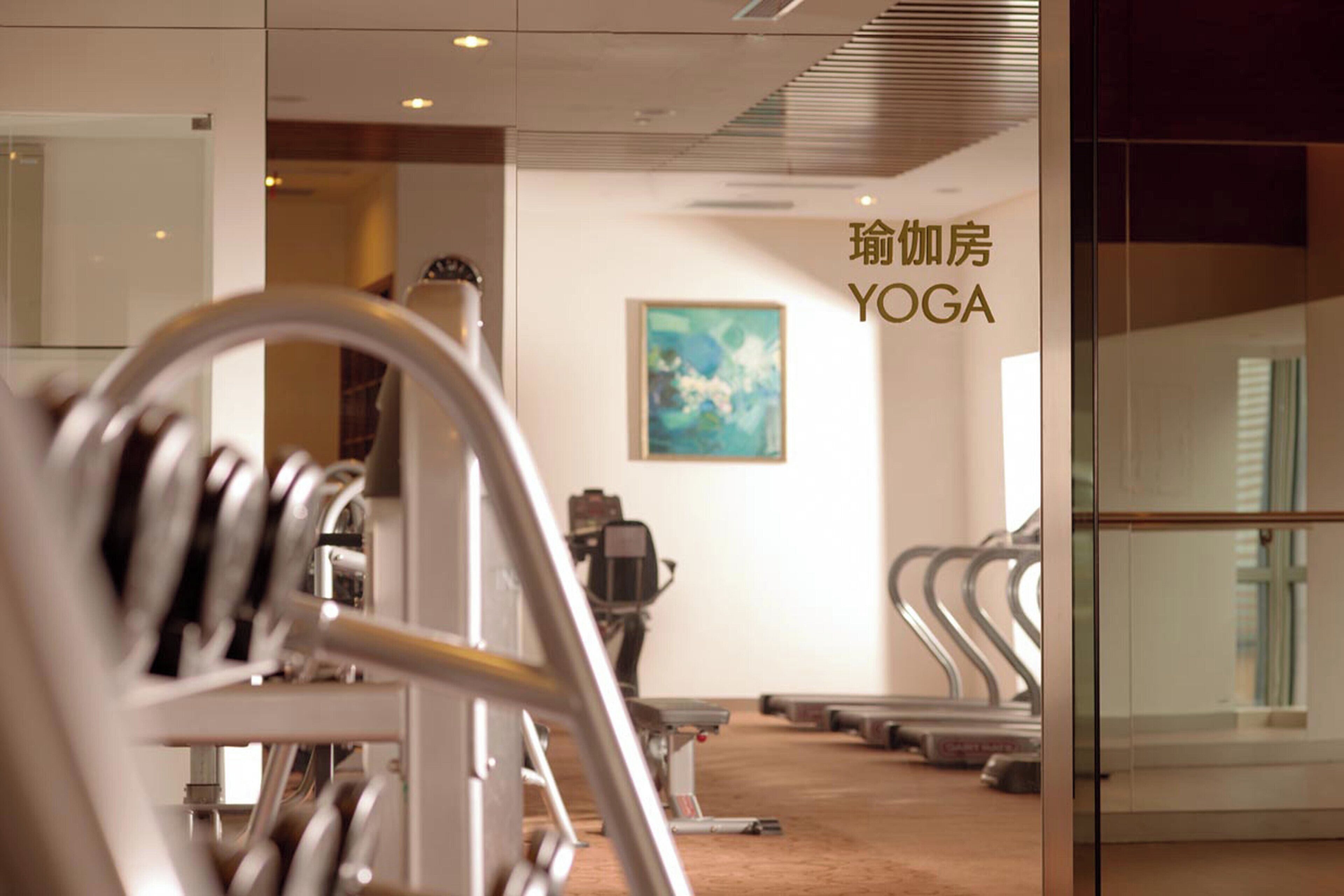 A yoga studio with exercise equipment and a painting on the wall.