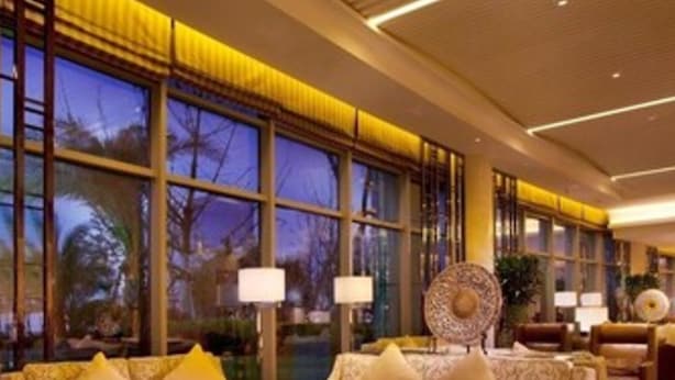 A hotel lobby with a sofa set, a coffee table, and a large decorative mirror. - Holiday Inn Shaoxing by IHG (Shaoxing)