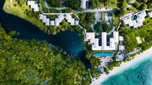 An aerial view of a resort with multiple buildings, a swimming pool, and a beach. - Kempinski Seychelles Resort (Mahé Island)