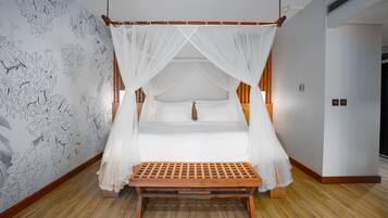 Quarto com cama de dossel, um banquinho de madeira e parede com padrão floral.