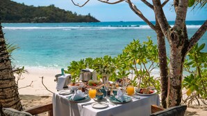 A table set for breakfast with a view of the ocean. - Kempinski Seychelles Resort (Mahé Island)