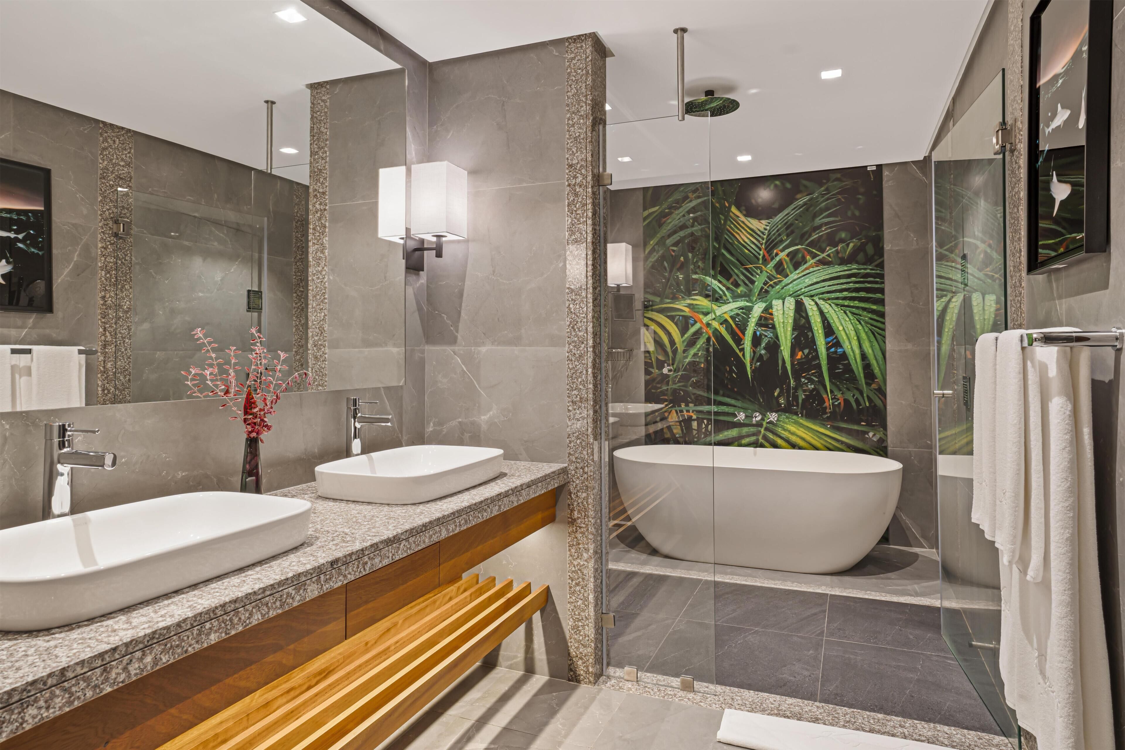 Ein modernes Badezimmer mit zwei Waschbecken, einer großen Badewanne und einer Duschkabine.