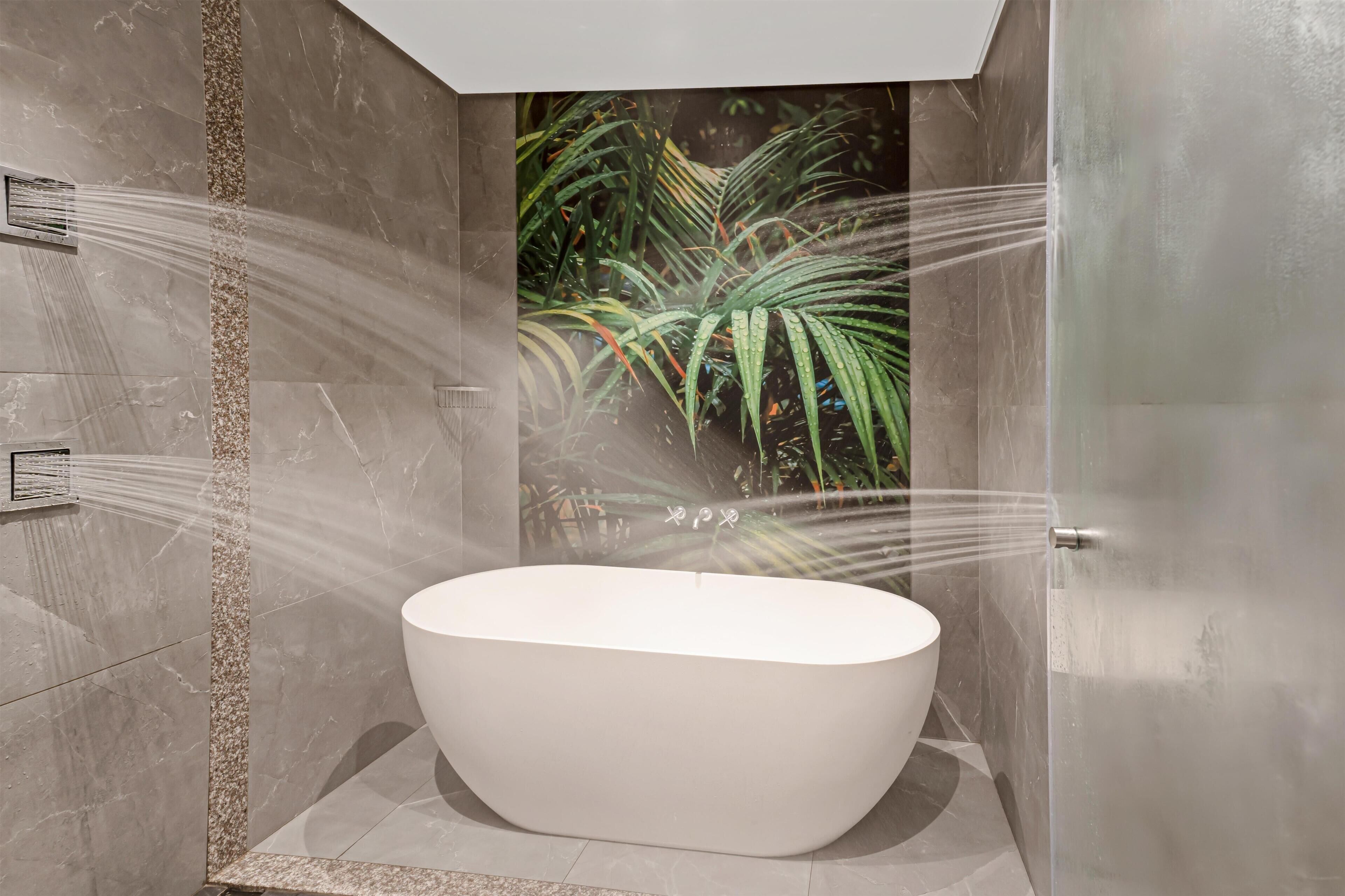 A modern bathroom with a freestanding bathtub, a showerhead, and a wall-mounted control panel.