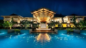 Una piscina al aire libre, sombrillas, sillones reclinables de piscina