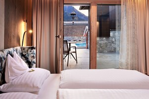 Un dormitorio con una cama grande, una silla y vistas a una zona de piscina exterior.