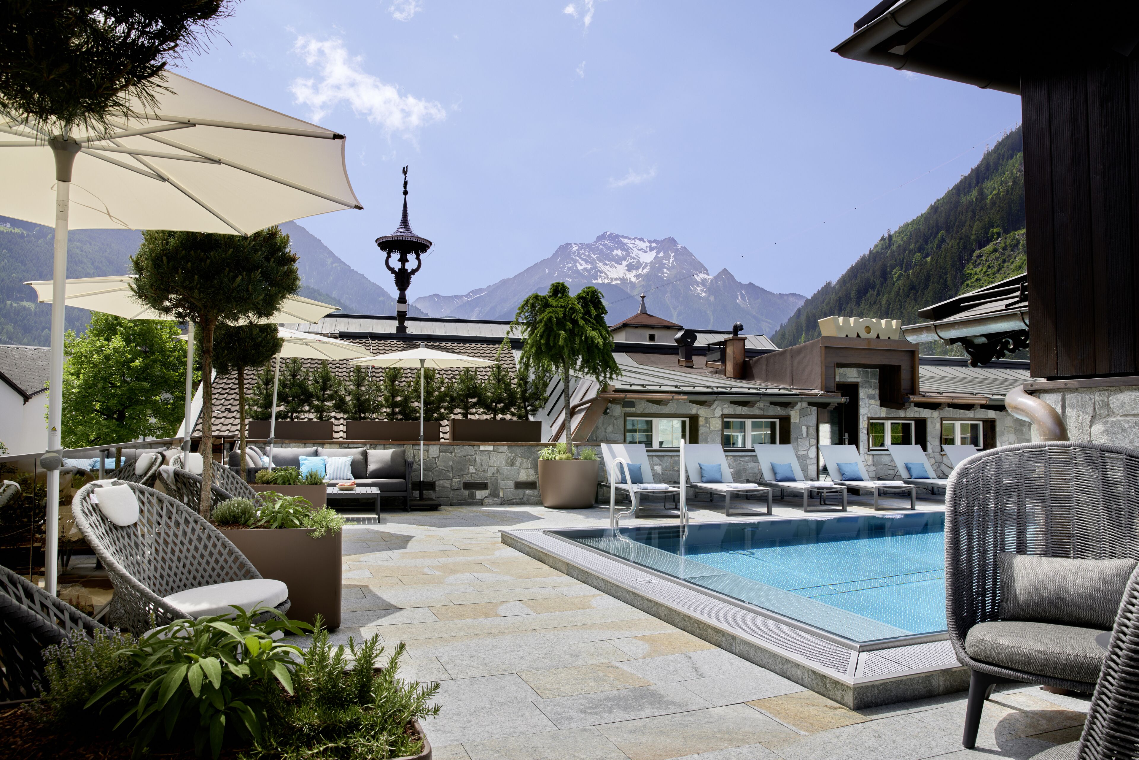 Una piscina techada, una piscina al aire libre, sombrillas