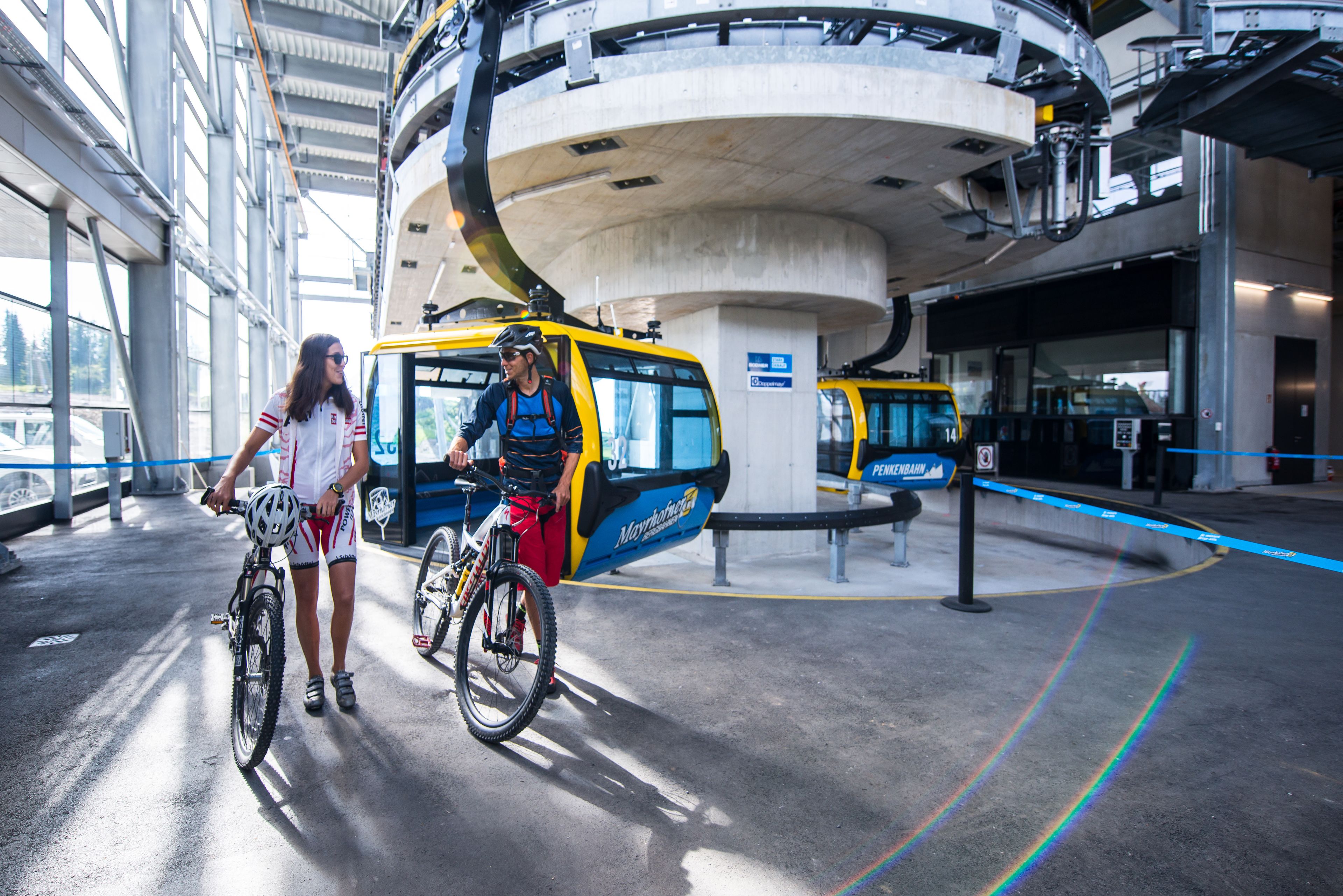 A covered bike parking area with a circular structure overhead and a blue barrier.