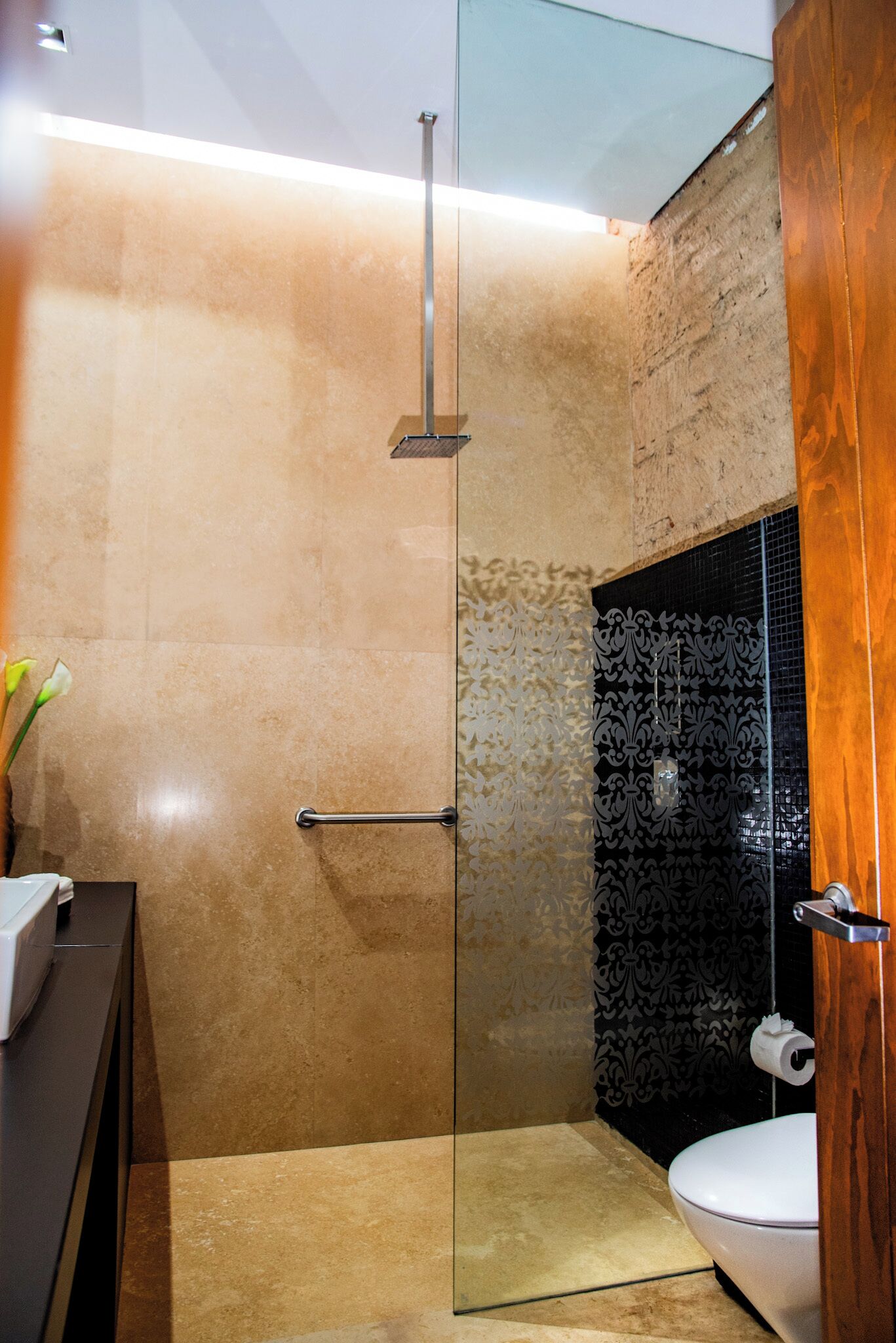 A modern bathroom with a glass shower enclosure, a toilet, and a vanity with a mirror.