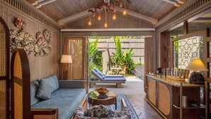 Una habitación acogedora con techo de madera, un sofá, una mesita de centro y una zona de bar con una lámpara.