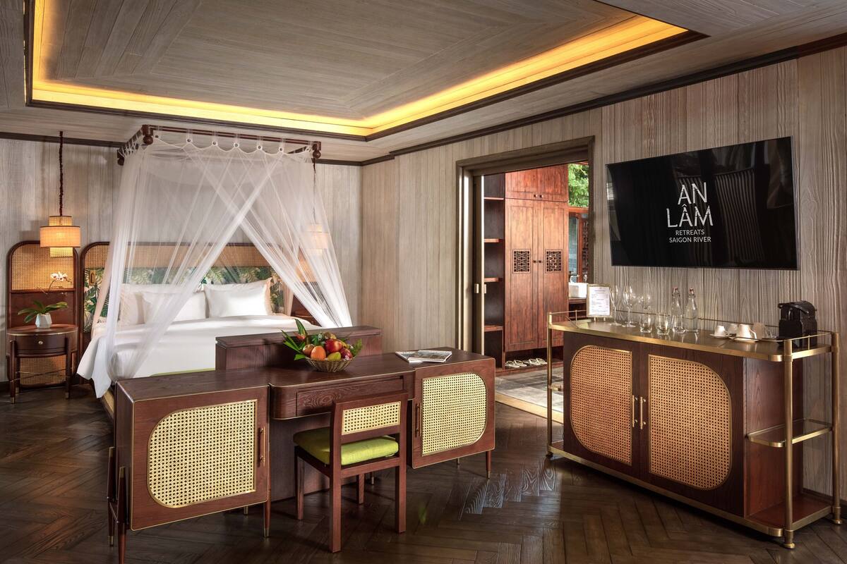 A hotel room with a bed, a TV, a desk with a computer, a chair, and a cabinet.