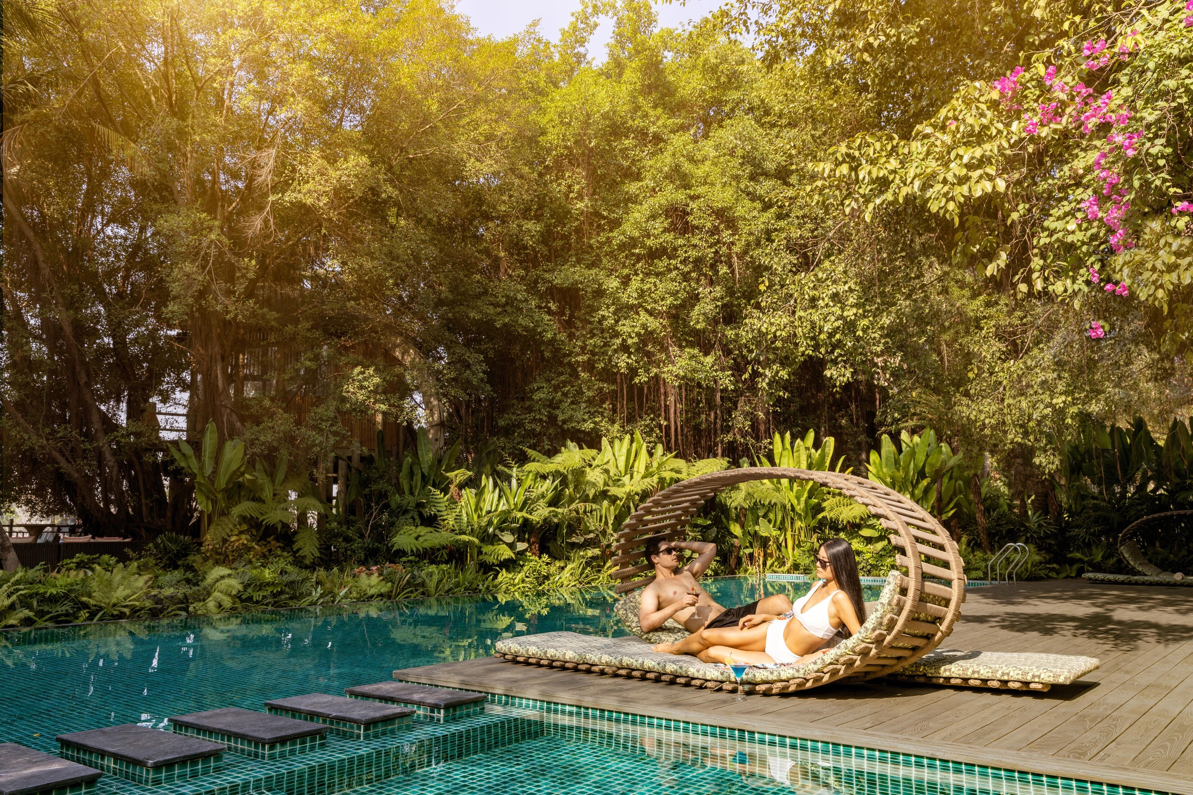 A poolside area with lounge chairs and a wooden deck.