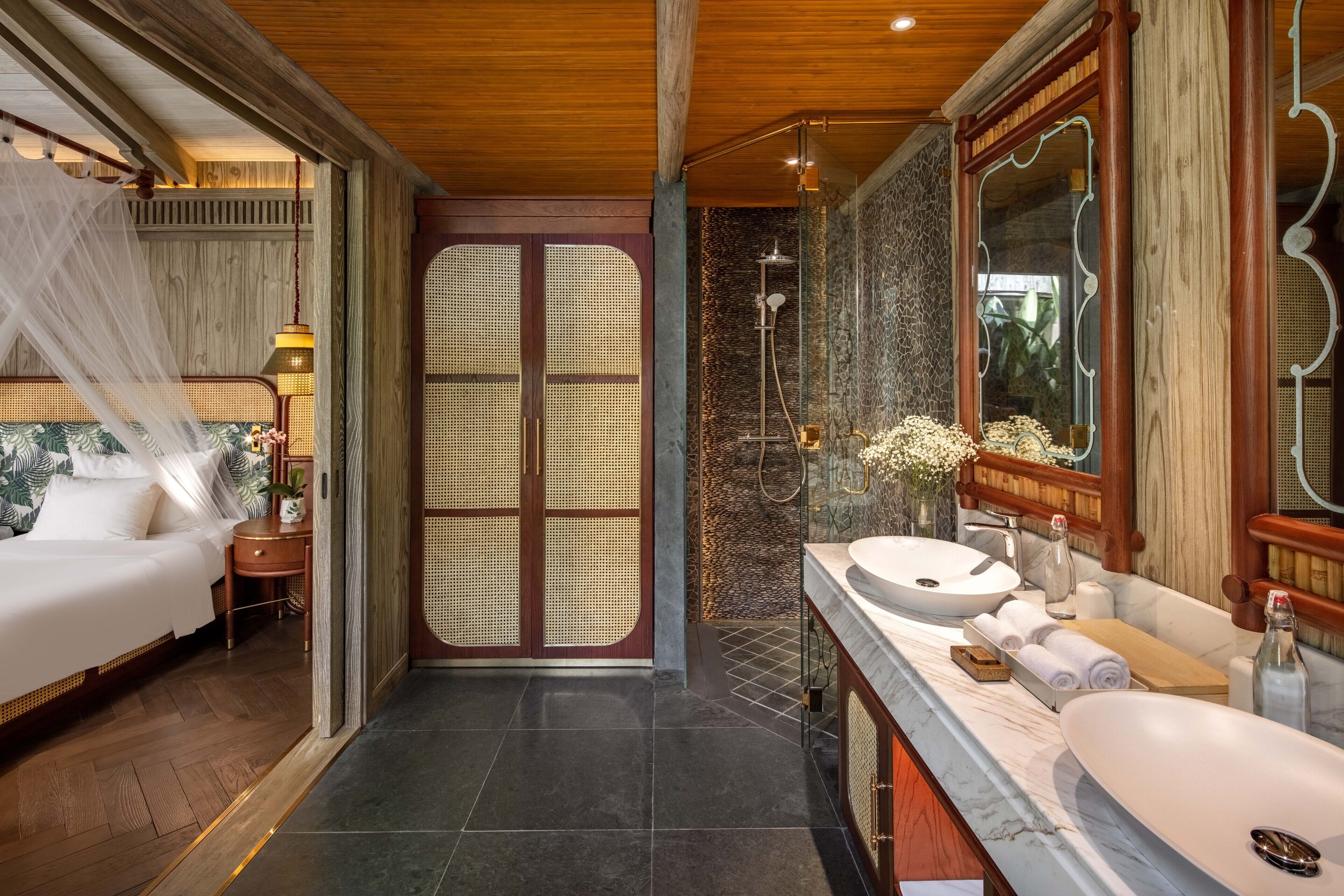 A modern bathroom with a large mirror, two sinks, and a shower.