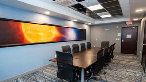 A conference room with a long table, black chairs, a large painting of a celestial scene, and a patterned carpet. - Holiday Inn Express & Suites Las Cruces North by IHG (Las Cruces)