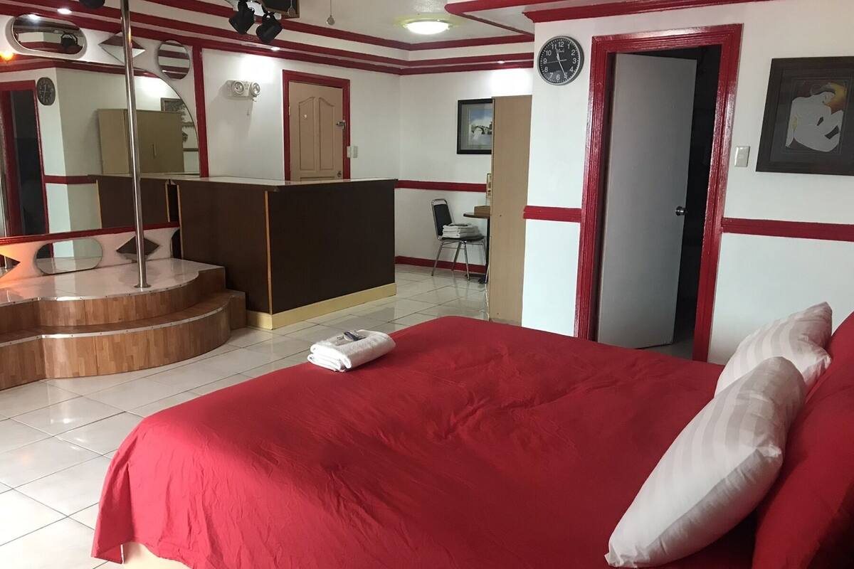 Ein Hotelzimmer mit einem großen Bett, einem Schreibtisch, einem Stuhl und einem kleinen Badebereich.