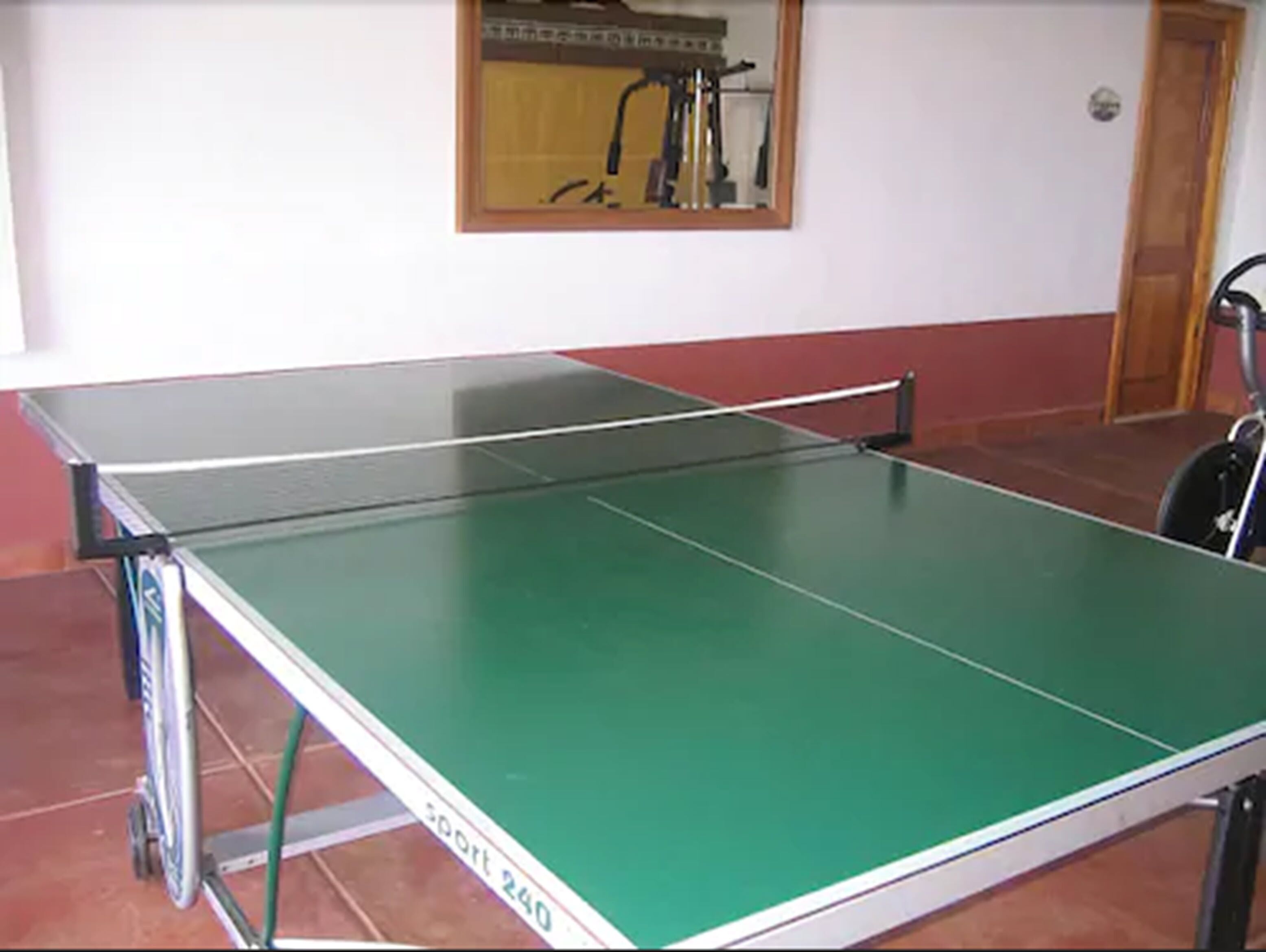A ping pong table with a metal frame and a green playing surface.