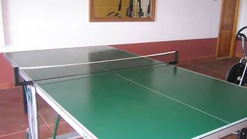 A ping pong table with a metal frame and a green playing surface.