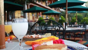 A table with a plate of pancakes, a glass of milk, and a glass of orange juice.